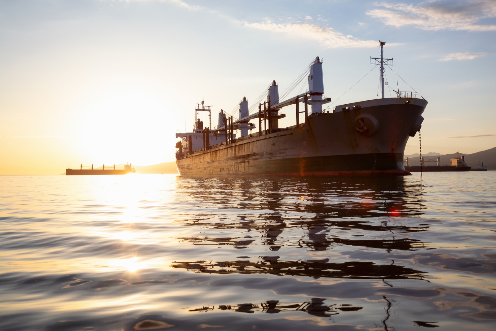 Vrachtschip op zee bij zonsondergang