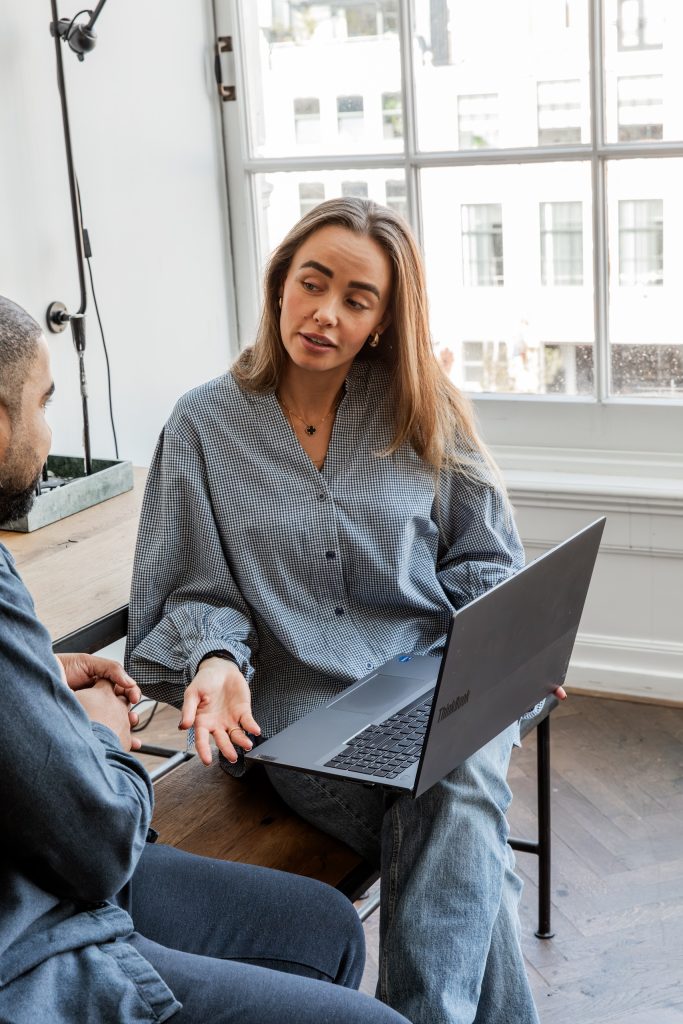 Twee collega’s van Consult&Co. in overleg met een laptop