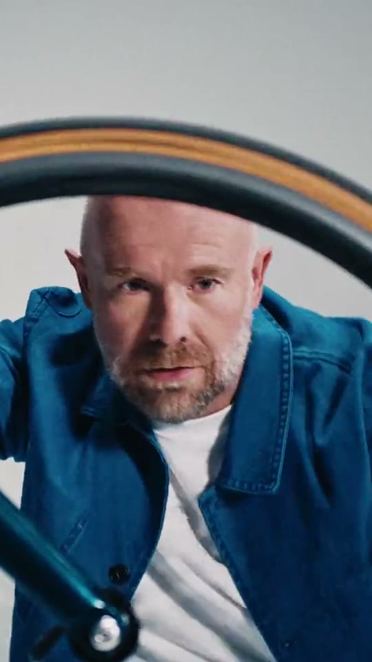 James, CEO van een fietsenfabriek, kijkt door een fietswiel